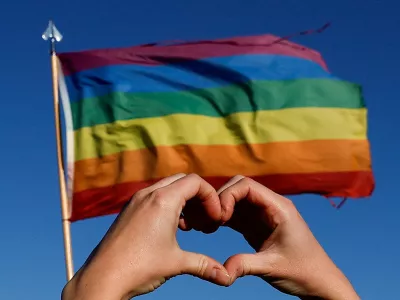 A person holds their hands in the shape of a heart in front of a pride flag during a march for solidarity for the those affected after a mass shooting at LGBTQ nightclub Club Q, in Colorado Springs, Colorado, U.S. November 26, 2022. REUTERS/Isaiah J. Downing   TPX IMAGES OF THE DAY