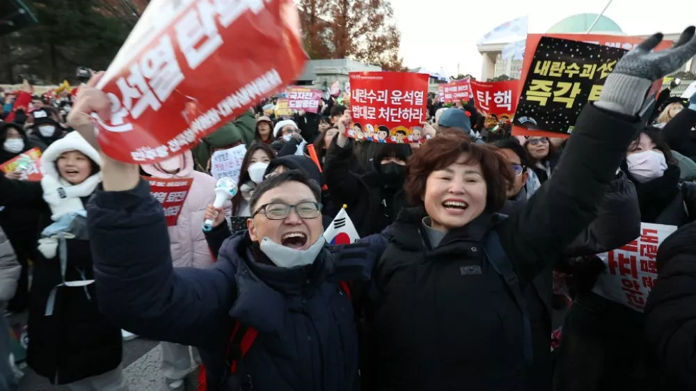 14 December 2024, South Korea, Seoul: Protesters cheer near the National Assembly following the passage of an impeachment motion against President Yoon Suk Yeol. The motion passed with a vote of 204-85, including three abstentions and eight invalid ballots. Photo: -/YNA/dpa