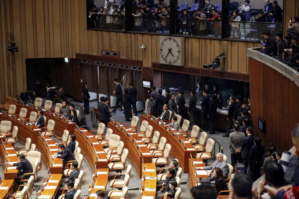 South Korean lawmakers queue to cast their votes during a plenary session of the impeachment vote of President Yoon Suk Yeol at the National Assembly in Seoul Saturday, Dec. 14, 2024. (Woohae Cho/Pool Photo via AP)