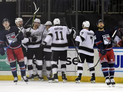 From left, Los Angeles Kings' Joel Edmundson, Andreas Englund, Alex Turcotte, Anze Kopitar and Kyle Burroughs celebrate as New York Rangers' Alexis Lafrenière, left, and Vincent Trocheck, right, react after Turcotte scored during the first period of an NHL hockey game, Saturday, Dec. 14, 2024, in New York. (AP Photo/Pamela Smith)