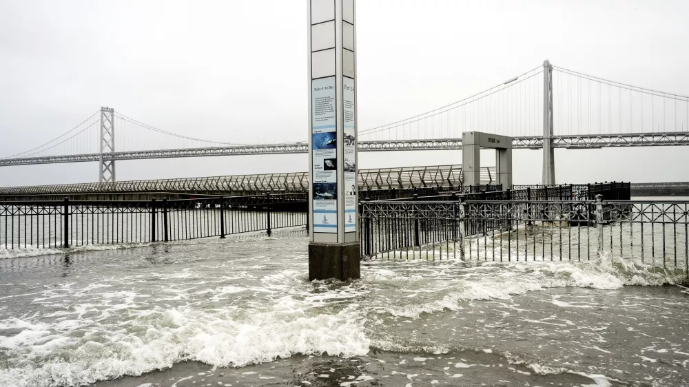 Water from the San Francisco Bay spills onto the Embarcadero in San Francisco on Saturday, Dec. 14, 2024, as a result of high tides and storm-driven waves. (AP Photo/Noah Berger)