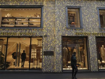 A man walks past a shop in Monte Napoleone street in Milan, Italy, Thursday, Dec. 12, 2024. (AP Photo/Antonio Calanni)