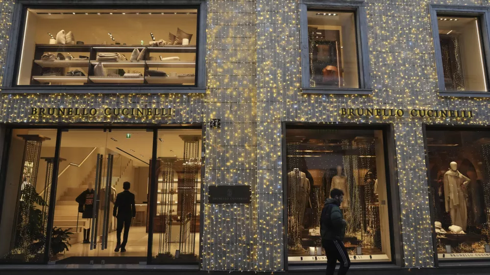 A man walks past a shop in Monte Napoleone street in Milan, Italy, Thursday, Dec. 12, 2024. (AP Photo/Antonio Calanni)