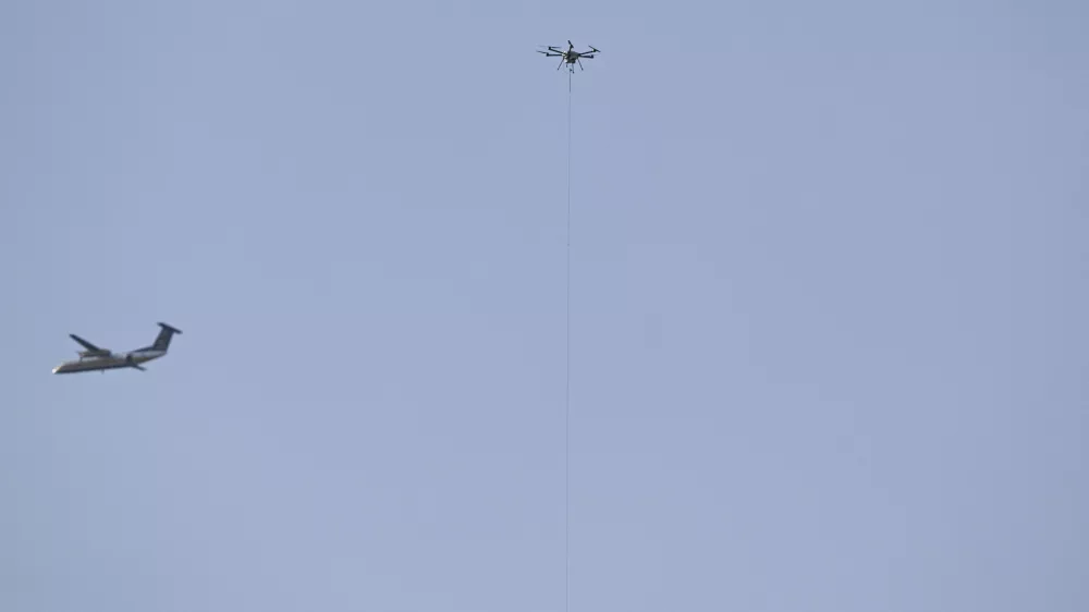 Dec 14, 2024; Landover, Maryland, USA;  An aircraft fly near a tethered drone during the first half of the125 plays of the Army-Navy game at Commanders Field. Mandatory Credit: Tommy Gilligan-Imagn Images