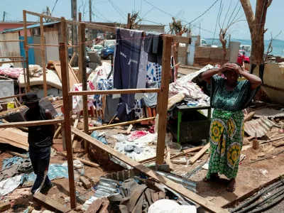 A woman reacts as she cleans her house in the aftermath of Cyclone Chido, in Mamoudzou, Mayotte, France December 18, 2024. REUTERS/Gonzalo Fuentes