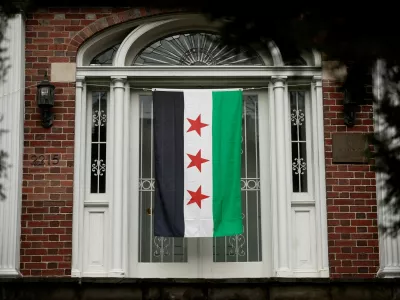 A Syrian opposition flag hangs on the entrance of the Syrian Embassy in Washington, U.S., December 18, 2024. REUTERS/Benoit Tessier