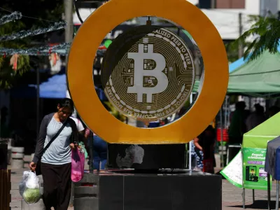 FILE PHOTO: A woman passes by the Bitcoin Monument after bitcoin soared above 0,000, in Ilopango, El Salvador, December 5, 2024. REUTERS/Jose Cabezas/File Photo