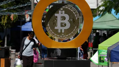 FILE PHOTO: A woman passes by the Bitcoin Monument after bitcoin soared above 0,000, in Ilopango, El Salvador, December 5, 2024. REUTERS/Jose Cabezas/File Photo