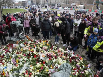 Citizens pay tribute for deaths outside St. John's Church near a Christmas Market, where a car drove into a crowd on Friday evening, in Magdeburg, Germany, Saturday, Dec. 21, 2024. (AP Photo/Ebrahim Noorozi)