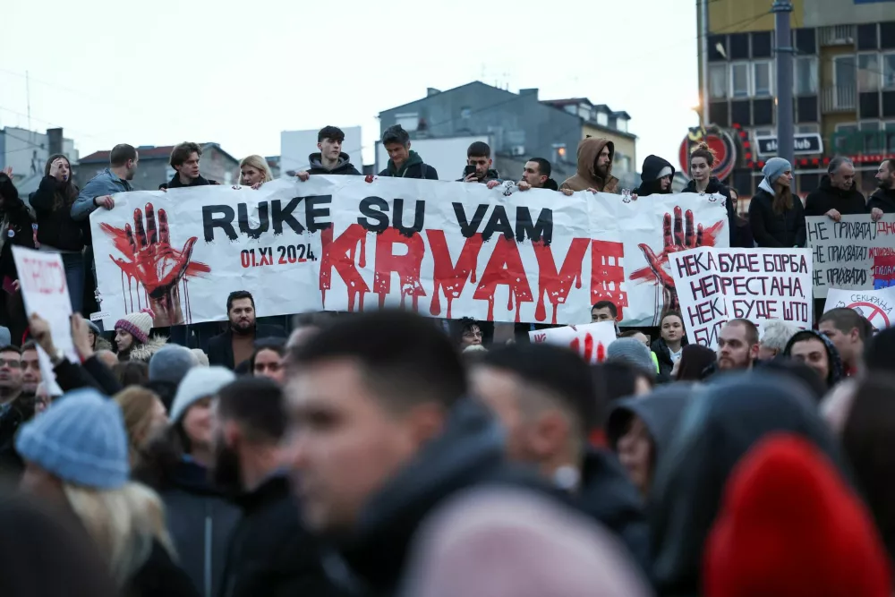 People carry a banner that reads ''your hands are bloody'', during a protest against government policies, corruption and the negligence which they blame for the deaths of the victims in the Novi Sad railway station disaster in November, in Belgrade, Serbia, December 22, 2024. REUTERS/Zorana Jevtic