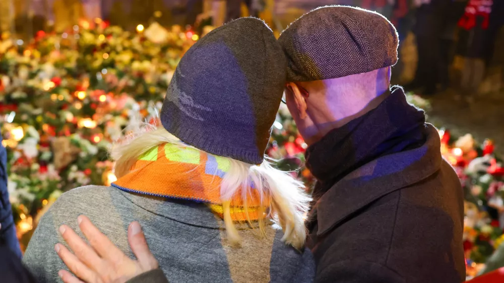 21 December 2024, Saxony-Anhalt, Magdeburg: People lay flowers and candles for the victims outside St. John's Church in Magdeburg, near the Christmas market where a driver rammed into a group of people on Friday evining. Photo: Jan Woitas/dpa