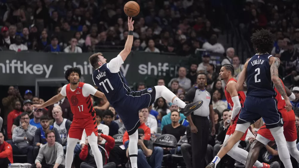 Dallas Mavericks guard Luka Doncic (77) shoots in front of Portland Trail Blazers guard Shaedon Sharpe (17) during the first half of an NBA basketball game Monday, Dec. 23, 2024, in Dallas. (AP Photo/LM Otero)