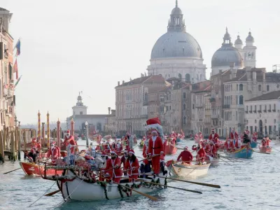 People dressed as Santa Claus row during a Christmas regatta along the Grand Canal in Venice, Italy, December 22, 2024. REUTERS/Manuel Silvestri   TPX IMAGES OF THE DAY