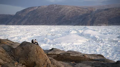 FILE - In this Aug. 16, 2019, file photo, NYU student researchers sit on top of a rock overlooking the Helheim glacier in Greenland. (AP Photo/Felipe Dana, File)