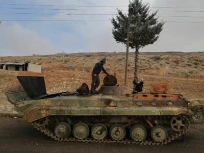 Ahmed and Khaled collect metal to sell from an abandoned Syrian army armoured personnel carrier (APC) outside Sednaya prison, which was known as a slaughterhouse under the rule of Syria's Bashar al-Assad, who was ousted, in Sednaya, Syria December 24, 2024. REUTERS/Zohra Bensemra