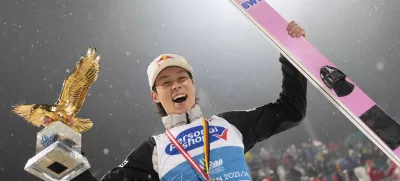 Ryoyu Kobayashi, of Japan, smiles with his trophy after winning the 72th Four Hills ski jumping tournament in Bischofshofen, Austria, Saturday, Jan. 6, 2024. (AP Photo/Matthias Schrader)