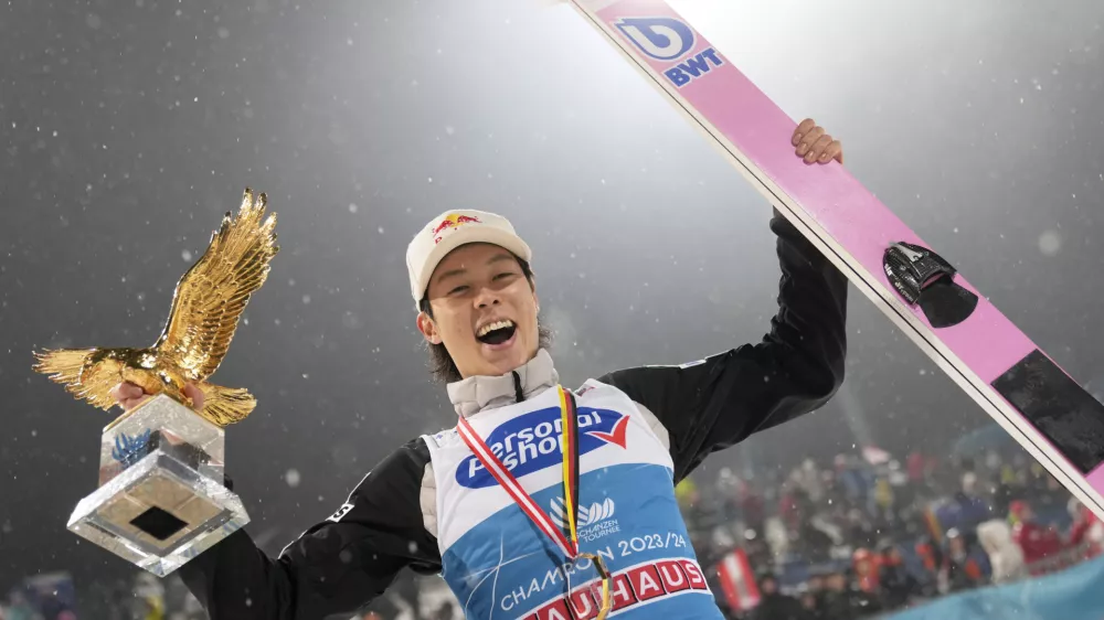 Ryoyu Kobayashi, of Japan, smiles with his trophy after winning the 72th Four Hills ski jumping tournament in Bischofshofen, Austria, Saturday, Jan. 6, 2024. (AP Photo/Matthias Schrader)