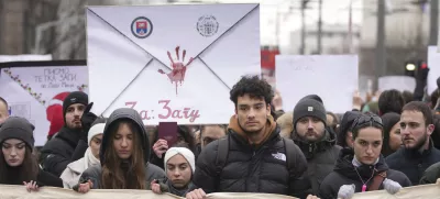 People stopping traffic, stand in silence during ongoing protests that erupted after a concrete canopy fell last month and killed 15 people in front of the government building in Belgrade, Serbia, Wednesday, Dec. 25, 2024. (AP Photo/Darko Vojinovic)