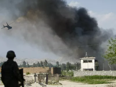 An Afghan National Army soldier keeps watch near the Provincial Reconstruction Team (PRT) as a NATO helicopter flies over the site of an attack in Jalalabad province April 15, 2012. Gunmen launched multiple attacks in the Afghan capital Kabul on Sunday, assaulting Western embassies in the heavily guarded, central diplomatic area and at the parliament in the west, witnesses and officials said. Taliban insurgents claimed responsibility for the assault, one of the boldest on the capital since U.S.-backed Afghan forces removed the group from power in 2001. REUTERS/Parwiz (AFGHANISTAN - Tags: CIVIL UNREST POLITICS TPX IMAGES OF THE DAY)