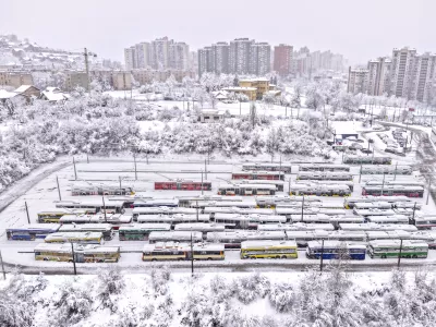 An aerial view of parked trolley buses during heavy snowfall in Sarajevo, Bosnia, Tuesday, Dec. 24, 2024. (AP Photo/Armin Durgut)