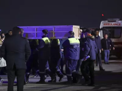 Workers carry a coffin with a body of a victim from a medical plane after the Azerbaijani Airline crashed, near the Kazakhstani city of Aktau, upon their arrival at the Heydar Aliyev International Airport outside Baku, Azerbaijan, Thursday, Dec. 26, 2024. (AP Photo)