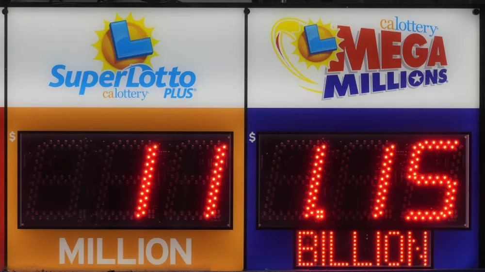 A sign advertising the estimated $1.15 billion Mega Millions jackpot, right, is displayed at Rossi's Deli in San Francisco, Thursday, Dec. 26, 2024. (AP Photo/Jeff Chiu)