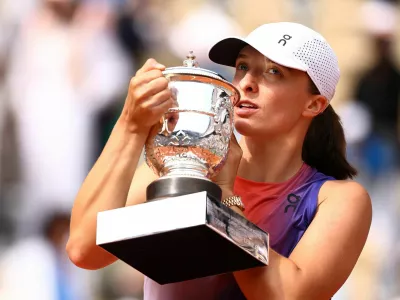 Tennis - French Open - Roland Garros, Paris, France - June 8, 2024 Poland's Iga Swiatek poses for a picture with the trophy after winning her final match against Italy's Jasmine Paolini REUTERS/Lisi Niesner