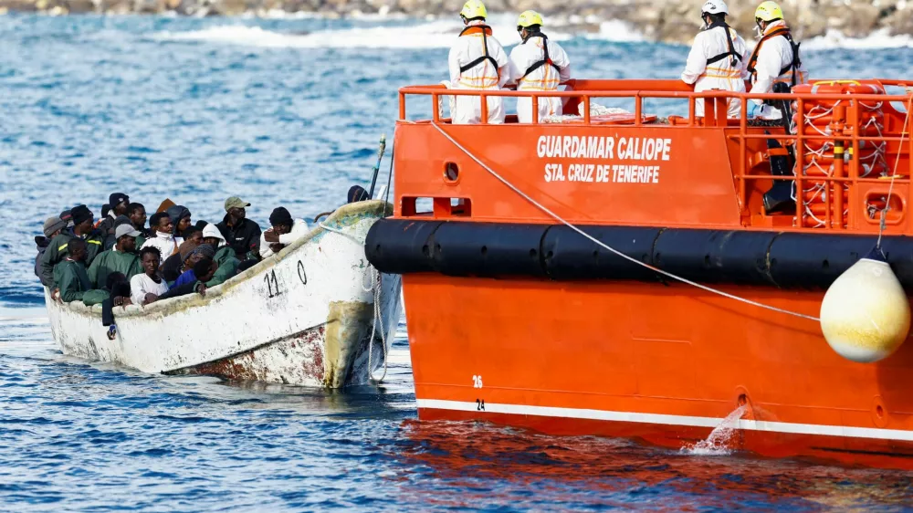 A Spanish Coast Guard vessel tows a fibreglass boat with migrants onboard to the port of Arguineguin, on the island of Gran Canaria, Spain, December 25, 2024. REUTERS/Borja Suarez