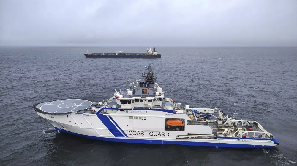 This photo provided by Rajavartiosto (Finnish Border Guard) on Thursday, Dec. 26, 2024, shows the oil tanker Eagle S, background, and the Finnish Border Guard ship Turva at sea outside Porkkalanniemi, Finland. The Eagle S was sailing at the same time in the area where the Finland-Estonia electrical link was disrupted on Wednesday. (Rajavartiosto via AP)