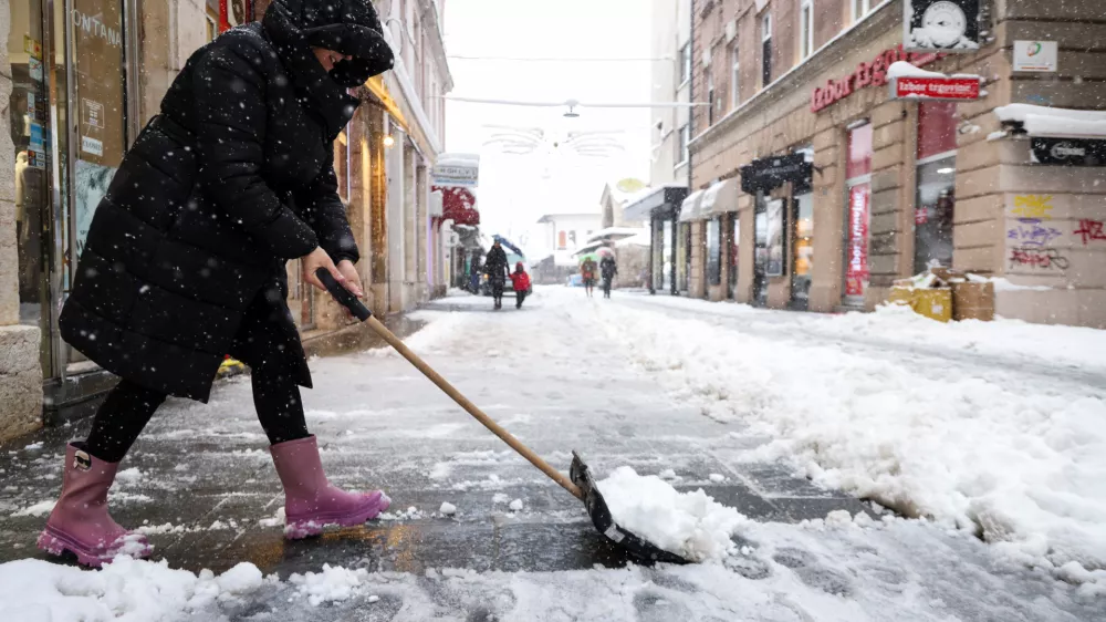 Ker so ob obilnem sneženju zatajile komunalne službe, so v mestih (na fotografiji Sarajevo) in vaseh ljudje sami poprijeli za snežne lopate ter se organizirali pri čiščenju cest in ulic. Foto: Reuters