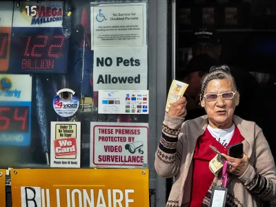 Diana Ramirez shows off her lottery tickets she bought at Joe's Service Center on Friday, Dec. 27, 2024 in Altadena, Calif. In 2022, the location had sold a .04 billion Powerball ticket. (AP Photo/Richard Vogel)