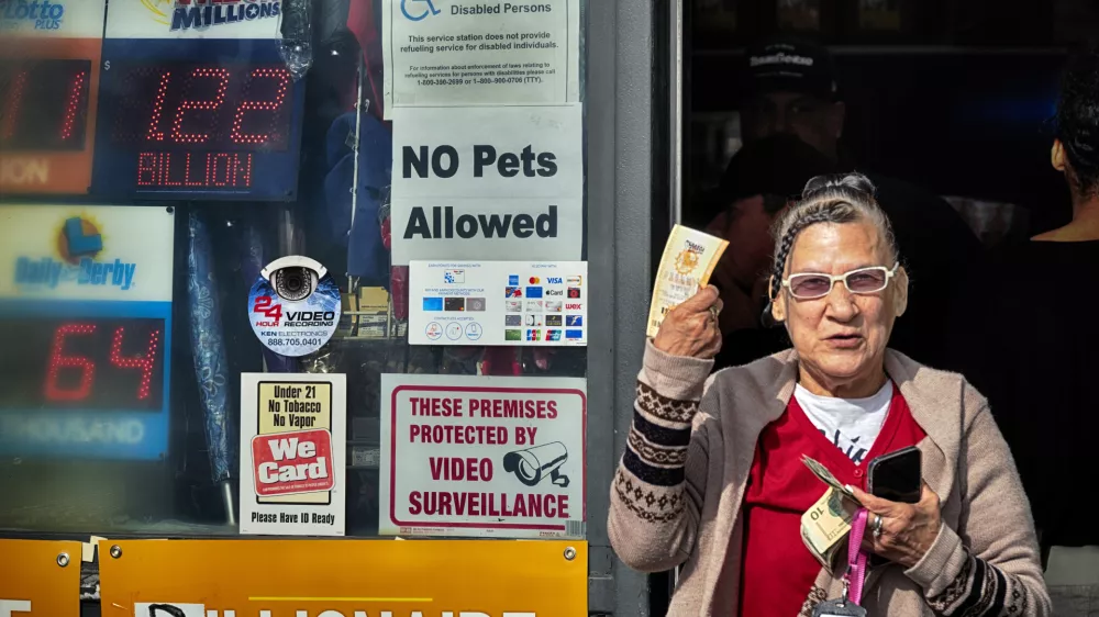 Diana Ramirez shows off her lottery tickets she bought at Joe's Service Center on Friday, Dec. 27, 2024 in Altadena, Calif. In 2022, the location had sold a $2.04 billion Powerball ticket. (AP Photo/Richard Vogel)