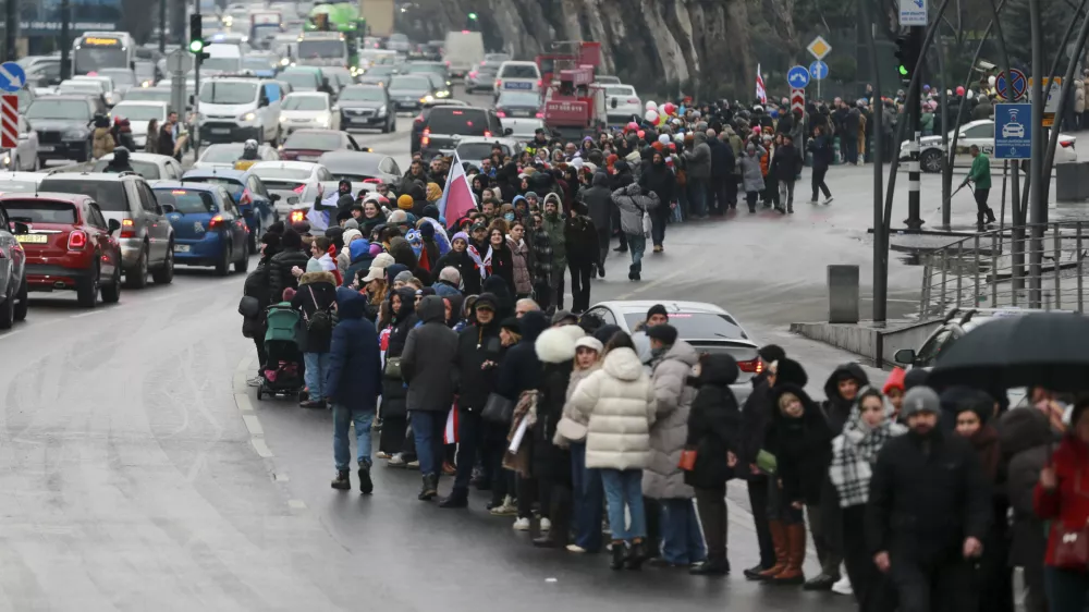 Demonstrators line up in a human chain during an anti-government rally in the center of Tbilisi, Georgia, on Saturday, Dec. 28, 2024. (AP Photo/Zurab Tsertsvadze)