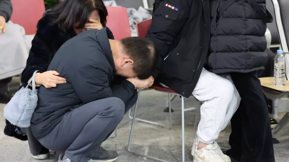 29 December 2024, South Korea, Muan: Family members of a victim of the Jeju Air plane crash mourn at Muan International Airport. Photo: -/YNA/dpa