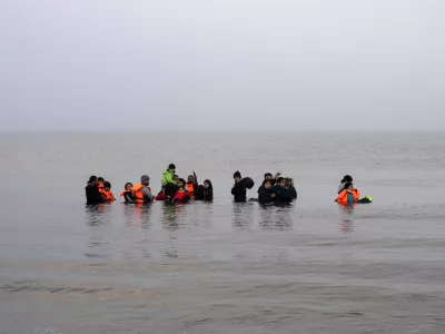 FILE - A group of Kurdish migrants from Iran and Iraq who failed in their attempt to reach the United Kingdom by boat after being discovered by the police refuse to return to shore on the beach of Ambleteuse, northern France, on May 19, 2024. (AP Photo/Bernat Armangue, File)