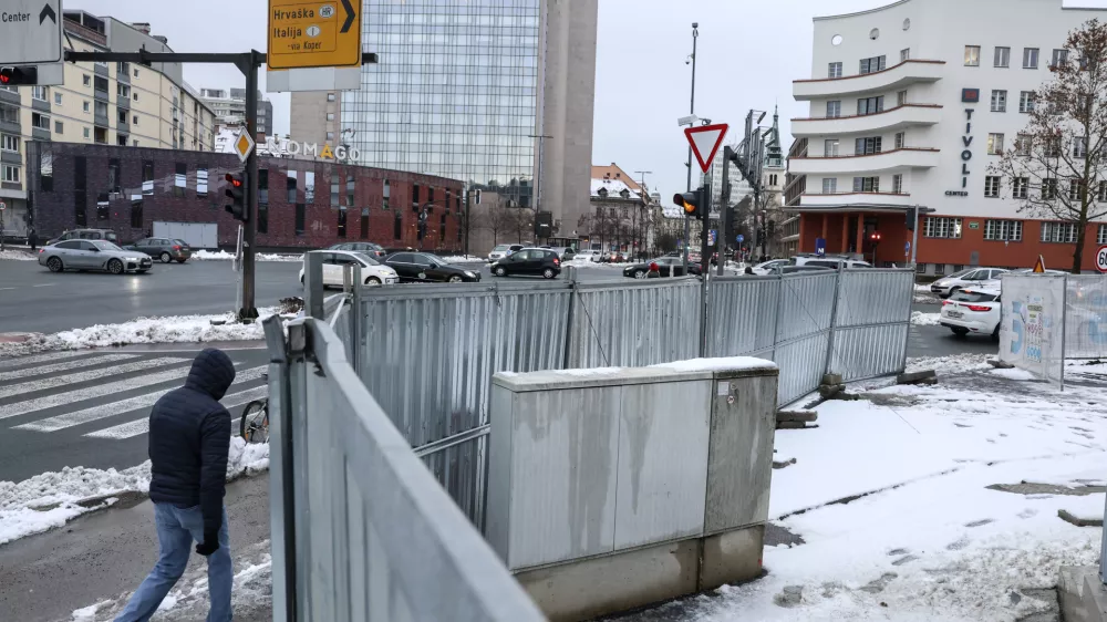 Ograja gradbišča Ilirija sega po novem tudi na pločnik in poteka okoli električne omarice. Na občini pojasnjujejo, da bo tako samo do januarja. Foto: Jaka Gasar