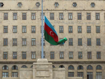 FILE PHOTO: An Azeri state flag flies at half-mast as the country observes day of national mourning for the victims of an Azerbaijan Airlines' Embraer passenger plane crash near the Kazakh city of Aktau, outside the Government House in Baku, Azerbaijan, December 26, 2024. REUTERS/Aziz Karimov/File Photo