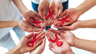 Group of young multiracial woman with red ribbons in hands are struggling against HIV/AIDS. AIDS awareness concept.