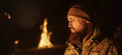 A Ukrainian serviceman aka Vovchok of 3rd assault brigade throws gunpowder into a fire during memorial ceremony of his fallen comrades during the winter solstice in Kharkiv region, Ukraine, Dec. 22, 2024. (AP Photo/Evgeniy Maloletka)