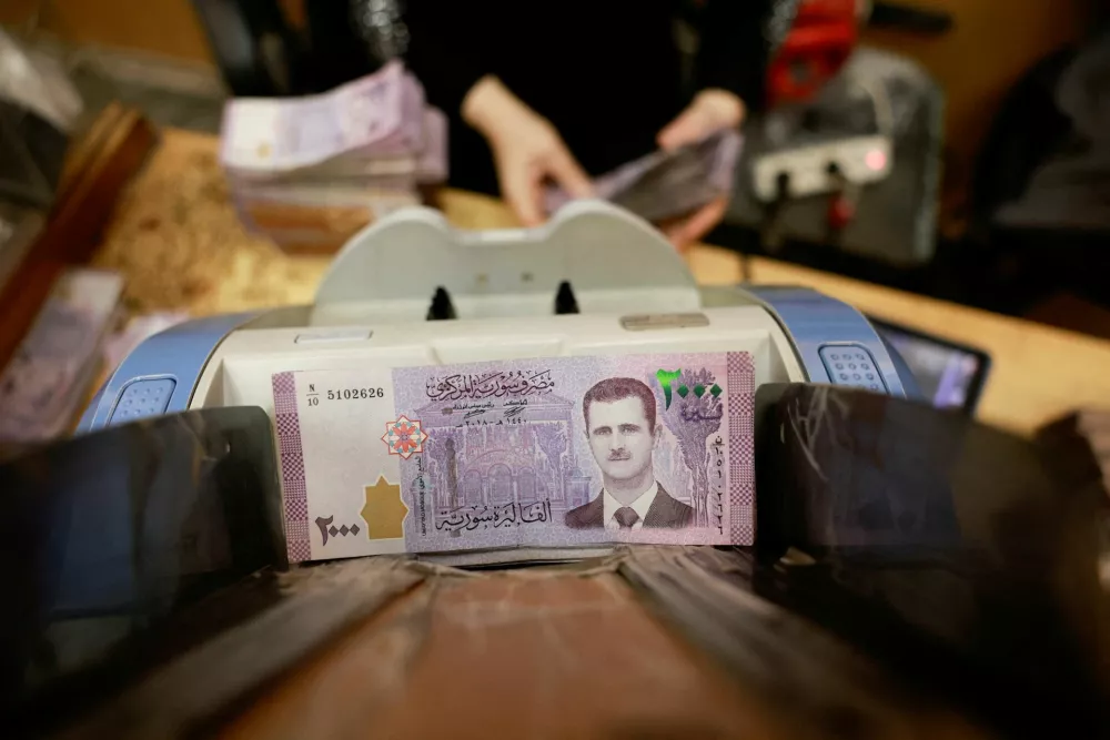 FILE PHOTO: An employee counts money at Syrian central bank, after the ousting of Syria's Bashar al-Assad, in Damascus, Syria, December 16, 2024. REUTERS/Ammar Awad/File Photo