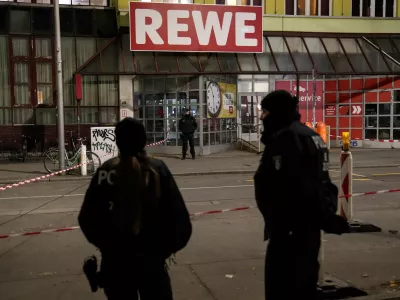 Police officers stand guard in front of a Rewe Market after a knife attack, in Berlin, Germany, Tuesday, Dec. 31, 2024. (AP Photo/Ebrahim Noroozi)