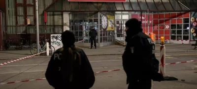 Police officers stand guard in front of a Rewe Market after a knife attack, in Berlin, Germany, Tuesday, Dec. 31, 2024. (AP Photo/Ebrahim Noroozi)