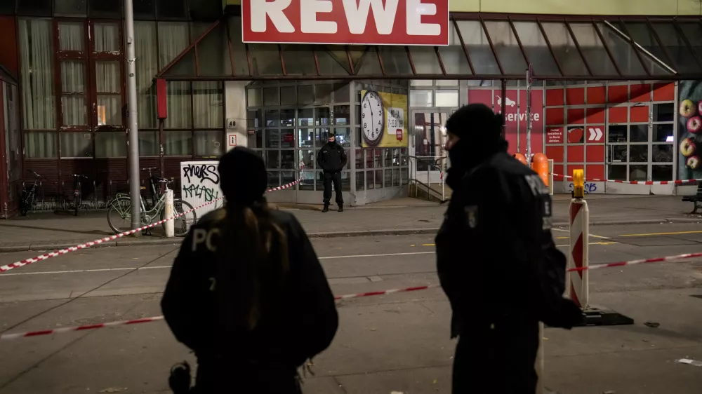 Police officers stand guard in front of a Rewe Market after a knife attack, in Berlin, Germany, Tuesday, Dec. 31, 2024. (AP Photo/Ebrahim Noroozi)