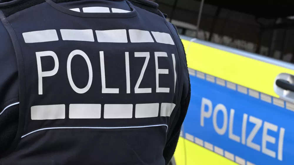 FILED - 03 December 2024, Baden-Württemberg, Stuttgart: A policeman is pictured next to a police car in Stuttgart. Photo: Bernd Weißbrod/dpa