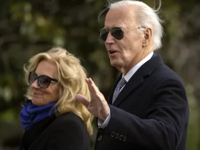 President Joe Biden gestures as he and first lady Jill Biden walk across the South Lawn of the White House, Thursday, Jan. 2, 2025, in Washington, after returning from Camp David. (AP Photo/Mark Schiefelbein)