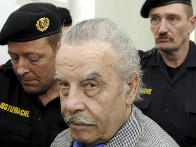 FILE - Josef Fritzl, center, is escorted to the fourth day of his trial in the provincial courthouse in St. Poelten, Austria, Thursday, March 19, 2009. An Austrian court has ruled that the man who kept his daughter captive for 24 years and raped her thousands of times, fathering seven children with her, can be moved from psychiatric detention to a regular prison. The decision follows a legal back-and-forth on Josef Fritzl's future. (AP Photo/Robert Jaeger, Pool, File)