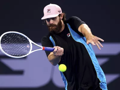 USA's Reilly Opelka plays a forehand to Serbia's Novak Djokovic during their match at the Brisbane International, in Brisbane, Australia, Friday, Jan. 3, 2025. (AP Photo/Pat Hoelscher)