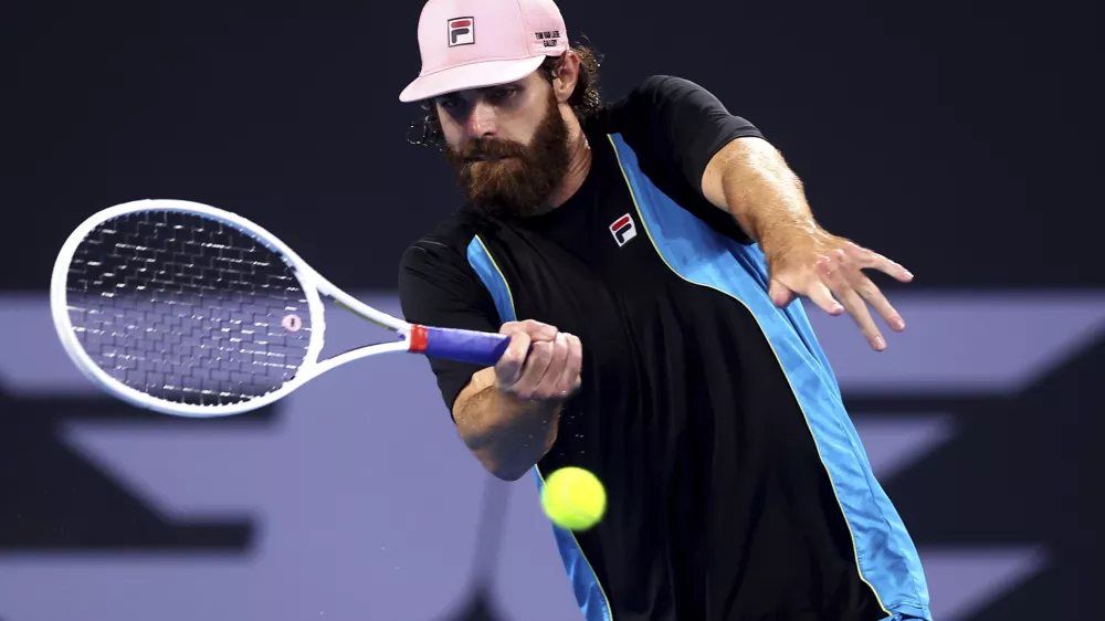 USA's Reilly Opelka plays a forehand to Serbia's Novak Djokovic during their match at the Brisbane International, in Brisbane, Australia, Friday, Jan. 3, 2025. (AP Photo/Pat Hoelscher)