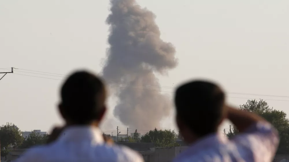 ﻿Turkish Kurds standing on the outskirts of Suruc, on the Turkey-Syria border, watch smoke rise following an airstrike in Kobani, Syria, where the fighting between militants of the Islamic State group and Kurdish forces intensified, Tuesday, Oct. 7, 2014. Kobani, also known as Ayn Arab and its surrounding areas have been under attack since mid-September, with militants capturing dozens of nearby Kurdish villages. (AP Photo/Lefteris Pitarakis)