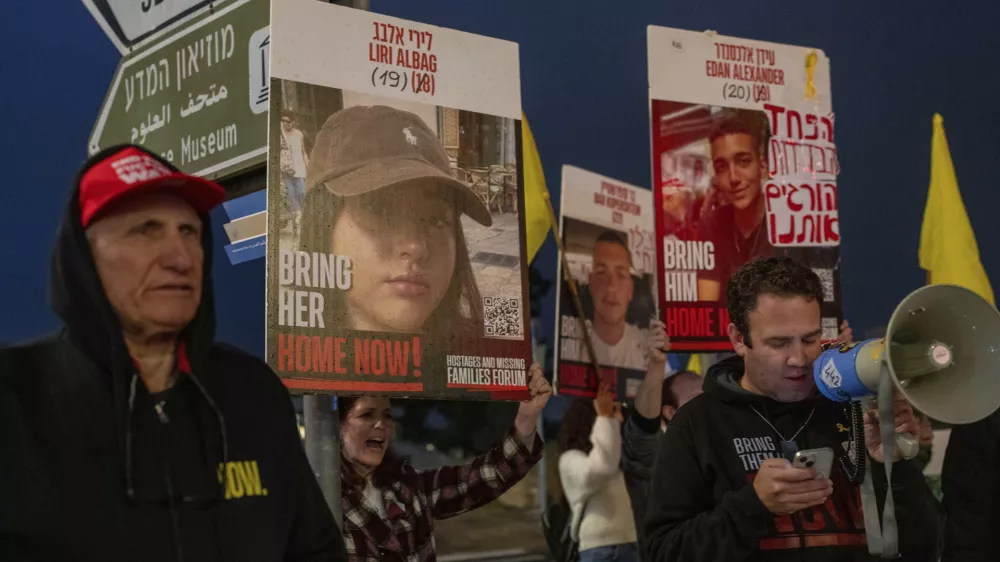 Israeli demonstrators outside the prime minister's office in Jerusalem hold photos of Liri Albag and other hostages during a protest calling for their release from being held in the Gaza Strip by the Hamas militant group, Sunday, Jan. 5, 2025. (AP Photo/Ohad Zwigenberg)